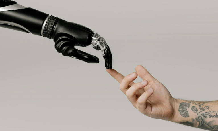 Robotic hand and human hand meeting with a touch to show the relationship between artificial intelligence and humanity